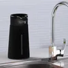 A black automatic soap dispenser sits on a kitchen counter next to a chrome faucet. Anteprima dell’immagine prodotto