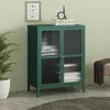 A green sideboard with glass doors is shown in a room with a plant and a stool. Podgląd zdjęcia produktu