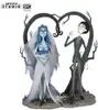 A figurine set of Victor and Emily from Corpse Bride, standing against a backdrop of stylized trees forming a heart shape. Náhled obrázku produktu