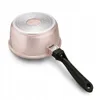 The bottom of a rose gold pot with a black handle is shown against a white background. Náhled obrázku produktu