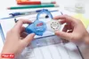 Hands holding a correction tape dispenser over a document. Anteprima dell’immagine prodotto