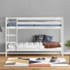 A white wooden bunk bed with bedding and pillows is shown in a room with a gray wall and a patterned rug on the floor. Produktbild-Vorschau