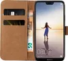 A brown flip-case wallet for a smartphone, with a smartphone displaying a beach scene. Produktbild-Vorschau