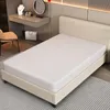 A white mattress on a beige bed frame in a bedroom setting. Produktbild-Vorschau