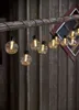 A string of decorative lights hanging from a wooden beam against a wooden wall. Podgląd zdjęcia produktu