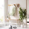 An entryway with a coat rack, bench, and plant. Produktbild-Vorschau