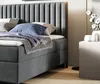 A close-up view of a bed with a gray upholstered headboard and base, dressed with pillows and a blanket. Anteprima dell’immagine prodotto