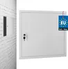 A white metal access panel with a key lock is shown mounted on a white brick wall. A tag indicating 'Made in EU' and the brand 'kotarbau' is attached to the panel. Podgląd zdjęcia produktu