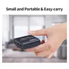 A hand holding a small black electronic device with text on it, with a blurred background of an office or living space. Produktbild-Vorschau