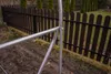 Close-up of a metal frame structure in a garden setting, with a wooden fence in the background. Náhľad obrázku produktu
