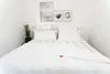 A neatly made bed with white bedding and a black grid pattern on the headboard and duvet. Produktbild-Vorschau