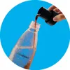 A hand is pouring a brown liquid from a black dispenser into a clear plastic bottle labeled 'sodastream'. Produktbild-Vorschau