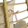 A close-up of a beige lounger chair with a pink ribbon tied around it. Produktbild-Vorschau