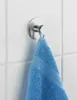 A silver wall hook with a blue towel hanging from it, mounted on a white tiled wall. Produktbild-Vorschau