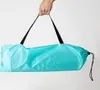 A hand holding a folded turquoise bag with black straps. Náhled obrázku produktu