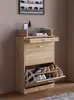 A shoe cabinet with shoes inside, placed against a wall. Produktbild-Vorschau