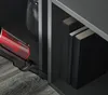 Vacuum cleaner being used to clean next to books on a shelf. Produktbild-Vorschau