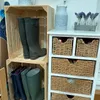 A collection of wooden crates and a white storage unit filled with boots and baskets, decorated with lavender. Náhled obrázku produktu