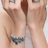 A close-up shot of a person's arms wearing jewelry. Anteprima dell’immagine prodotto