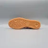 The sole of a black and pink Adidas Handball Spezia sneaker is shown against a plain gray background. Produktbild-Vorschau