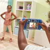 A child is taking a picture of another child with a toy camera in a room. Produktbild-Vorschau