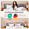 A woman is lying in bed under a duvet, holding a pillow. The image also features certifications and logos. Produktbild-Vorschau