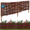A woven willow garden border fence with pink flowers and green grass. Náhled obrázku produktu
