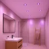 A modern bathroom with a vanity, mirror, shower, and ladder with a towel, illuminated by pink ceiling lights. Produktbild-Vorschau