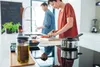 A couple is preparing food in a modern kitchen. Voir les images du produit