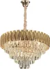 A gold and crystal chandelier hanging from a light pink cord. Produktbild-Vorschau