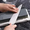 Hands sharpening a knife on a whetstone. Produktbild-Vorschau