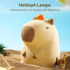 A cute capybara-shaped lamp sitting on a sandy beach with two small bottles of drink next to it. Produktbild-Vorschau