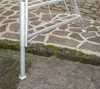 Close-up of the base of an aluminum garden ladder standing on a stone patio. Voir les images du produit