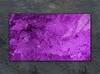 A purple glass cutting board is placed on a dark, textured surface. Náhled obrázku produktu