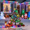 A festive outdoor Christmas decoration scene with inflatable figures and illuminated trees. Produktbild-Vorschau
