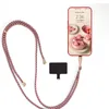 A smartphone with a pink cake wallpaper, attached to a braided lanyard, and a small black accessory. Produktbild-Vorschau
