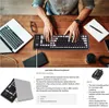A person's hands are typing on a portable silicone keyboard next to a laptop on a wooden desk. Produktbild-Vorschau