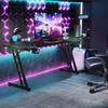 A modern gaming setup with a desk, computer, and chair, illuminated by colorful LED lights. Produktbild-Vorschau
