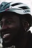 Close-up of a person wearing a white and black bicycle helmet. Produktbild-Vorschau