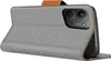 A close-up, angled view of a grey flip phone case with brown leather accents, showing the camera cutout on the back. Podgląd zdjęcia produktu