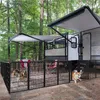 Two dogs are playing in a fenced-in area next to a recreational vehicle (RV) in a wooded area. Podgląd zdjęcia produktu