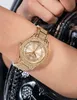 A close-up shot of a gold Guess watch with sparkling details on a woman's wrist, with a black sequined garment in the background. Podgląd zdjęcia produktu