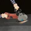 A person wearing gloves and a plaid shirt is using a wall chaser to cut a metal rod on a dark surface. Náhled obrázku produktu