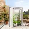A small greenhouse with plants on a balcony with a wooden fence and a chair. Produktbild-Vorschau