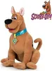 A plush toy of Scooby-Doo is sitting on a white background, with the Scooby-Doo logo and cartoon character in the upper right corner. Náhled obrázku produktu