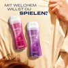 Two Durex massage and lube bottles are placed on a rumpled cream-colored sheet, with a hand pulling the sheet in the background. Podgląd zdjęcia produktu