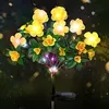 A solar-powered string of yellow flowers with green leaves, illuminated at night. Náhled obrázku produktu