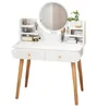 A white vanity table with a round mirror and wooden legs, adorned with various cosmetic items and decorative elements. Podgląd zdjęcia produktu