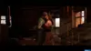 A couple embracing in a dimly lit, rustic interior with sunlight streaming through a window. Produktbild-Vorschau