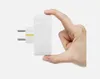A hand is holding a white electrical adapter to show its size. Produktbild-Vorschau